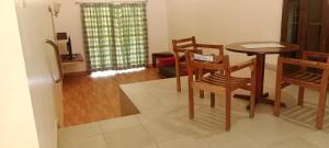 a dining room with a table and chairs in a room at Ksr woodland Residency in Kodaikānāl +23 photos