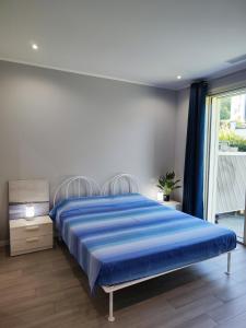Un dormitorio con una cama con sábanas azules y una ventana. en Iseo garden suite, en Paratico