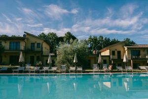 a large swimming pool with chairs and umbrellas at Fattoria degli Usignoli in San Donato in Fronzano