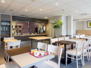 モンペリエにあるB&B HOTEL Montpellier Centre Le Millénaireのテーブルと椅子、カウンター付きのレストラン