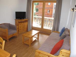 a bedroom with a bed and a tv and a table at Wohnung GREPPON NEND200 Ski in and Ski out in Nendaz