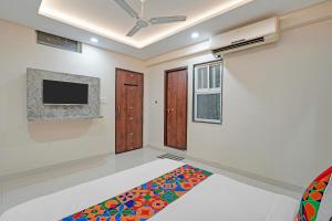 sala de estar con TV y alfombra en FabHotel Elite Inn I, en Indore