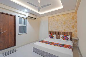 a bedroom with a bed and a wooden door at FabHotel Elite Inn I in Indore