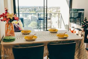 a table with four bowls and a vase with flowers at Trainer's Cozy Home - Town of Beginnings マサラタウンのトレーナーのおうち in Melbourne