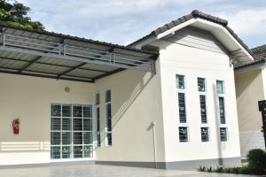 una gran casa blanca con solárium en Khwanlom House, en Lampang