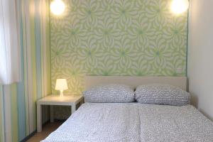 Bungalow Leuchtturm im Ostseeidyll am Waldrand في أوستسيباد نينهاجن: غرفة نوم بسرير وجدار بورق جدران