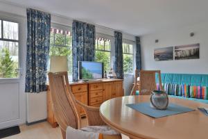 Bungalow Leuchtturm im Ostseeidyll am Waldrand في أوستسيباد نينهاجن: غرفة طعام مع طاولة وبعض النوافذ