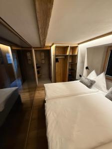 a bedroom with two white beds in a room at TheNEST1895 in Zermatt