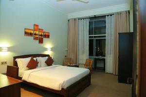 a hotel room with a bed and a desk and a bedroom at Oak Ray Misty Hills in Nuwara Eliya