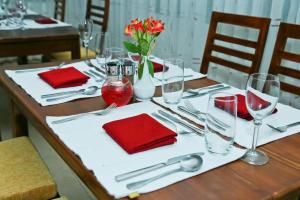 a wooden table with red napkins and silverware on it at Oak Ray Misty Hills in Nuwara Eliya