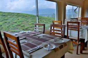 a dining room with a table and chairs and a window at Oak Ray Misty Hills in Nuwara Eliya