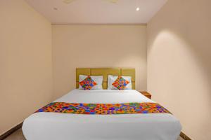 1 dormitorio con 1 cama grande con sábanas coloridas en FabHotel Siddarth Grand, en Vijayawada