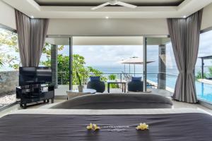 ein Schlafzimmer mit Bett und Blick auf das Meer in der Unterkunft Suluban Cliff Bali Villa in Uluwatu