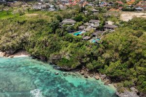eine Luftaufnahme eines Resorts auf einem Hügel neben dem Meer in der Unterkunft Suluban Cliff Bali Villa in Uluwatu