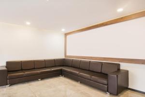 a couch in a room with a large window at Hotel O Meridian in Bijāpur
