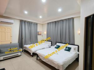 a bedroom with two beds and a tv in it at NIR Villa in Dumaguete