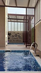 a pool with a water fountain in a building at استراحة جبال مصفوت in Şufayrī