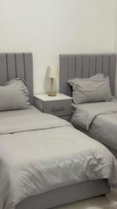 a bedroom with two beds and a lamp on a night stand at استراحة جبال مصفوت in Şufayrī