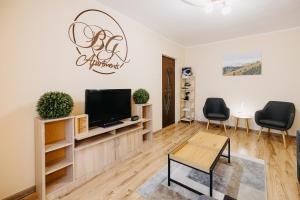 a living room with a tv and two chairs at B-G Apartments in Gheorgheni