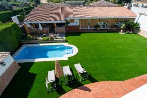 ein Hof mit Swimmingpool und Liegewiese in der Unterkunft Panther Home Villa Valencina in Valencina de la Concepción