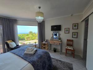 a bedroom with a bed and a large window at Villa Cape Garden Route in Wilderness