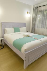 een wit bed in een kamer met een raam bij Azania Homes Residence-Opposite Movenpick Hotel in Nairobi