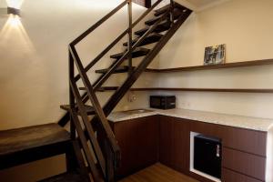 a staircase in a room with a microwave at Alpha Wolf Lodge in Cemagi