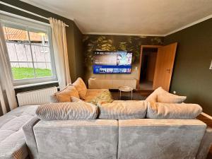 Una sala de estar con un sofá y un televisor de pantalla plana. en Casa Westerwohl, en Dierdorf