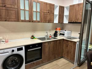 a kitchen with a sink and a washing machine at Divine place Majestic 90 in Pomorie