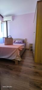 a bedroom with a bed and a wooden floor at Divine place Majestic 90 in Pomorie