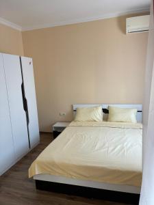 a bedroom with a white bed and a white cabinet at Divine place Majestic 90 in Pomorie +2 photos