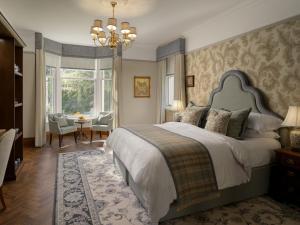 a bedroom with a large bed with a chandelier at Marcliffe in Aberdeen