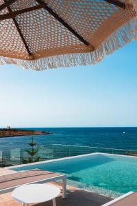 a swimming pool with a view of the ocean at XVI Suites - Adults Only in Naxxar