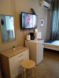 a room with a tv and a desk and a bed at Plaka Rooms in Athens