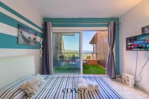 a bedroom with a bed and a sliding glass door at Blue Skyline | Sea View Terrace in Portisco in Olbia
