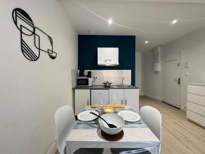 a dining room with a table and chairs and a kitchen at C Helsinki - Studio cosy près du centre-ville in Charleville-Mézières +8 photos