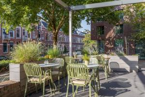 a group of tables and chairs under an umbrella at Leonardo Hotel Breda City Center in Breda