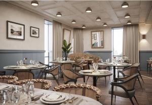 a restaurant with tables and chairs in a room at Swissôtel Marianske Lazne in Mariánské Lázně
