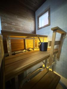 eine Holzbank in einem Raum mit einem Eimer darauf in der Unterkunft Riihen Tupa in Äkäslompolo