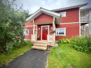ein rotes Haus mit einer roten Tür und einer Veranda in der Unterkunft Riihen Tupa in Äkäslompolo
