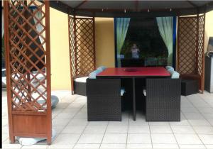 a red table and chairs on a patio at Nuit etoile avec Jacuzzi prive in Fouesnant +2 photos