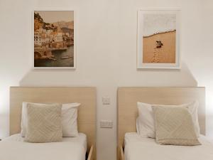 Nova في Qala: سريرين في غرفة نوم مع صورتين على الحائط