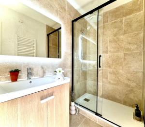 a bathroom with a sink and a glass shower at Le Joyau d'Aristide - Appartement Confort en Hyper-Centre à deux pas du Théâtre Antique - Climatisation in La Celle-sous-Gouzon