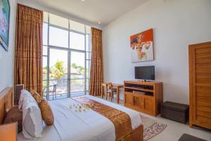 Villa Efes Bali في سمينياك: غرفة نوم بسرير وتلفزيون ونافذة