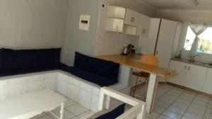 a small kitchen with a table and a blue couch at 35 Pearce in Vosburg