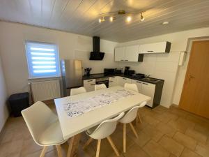 a kitchen with a white table and white chairs at Beetzseeperle in Brandenburg an der Havel +3 photos