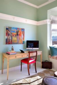 una habitación con un escritorio con una computadora y una silla en Hillside House, en Fish Hoek