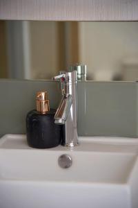 a bathroom sink with a faucet and a cup on it at Serene escape in Johannesburg in Fourways