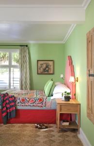 1 dormitorio con 1 cama con cabecero rojo y mesa en Hillside House, en Fish Hoek 60 fotos más