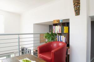 a red chair sitting in front of a book shelf at Serene escape in Johannesburg in Fourways